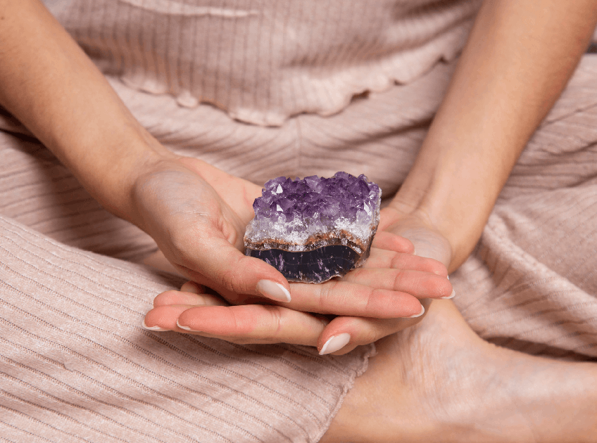 hands holding purple crystal 1 1
